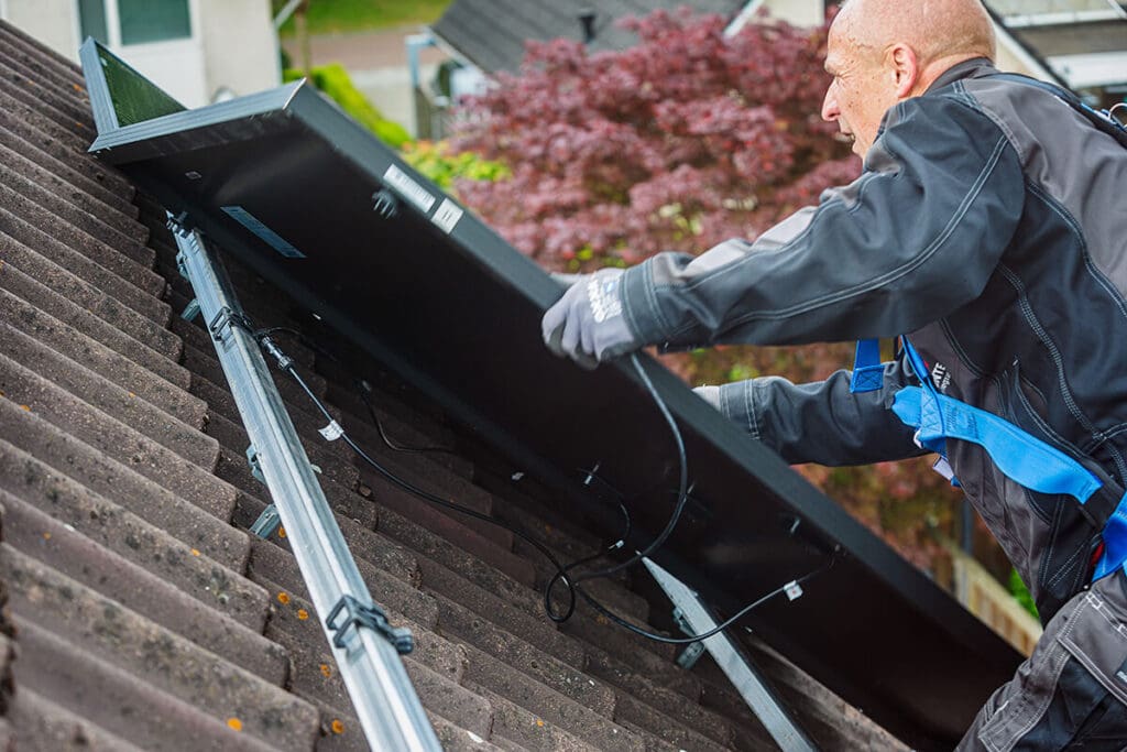 man installing a solar roof panel