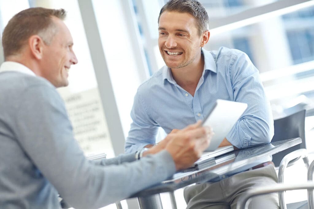 two smiling men in a meeting